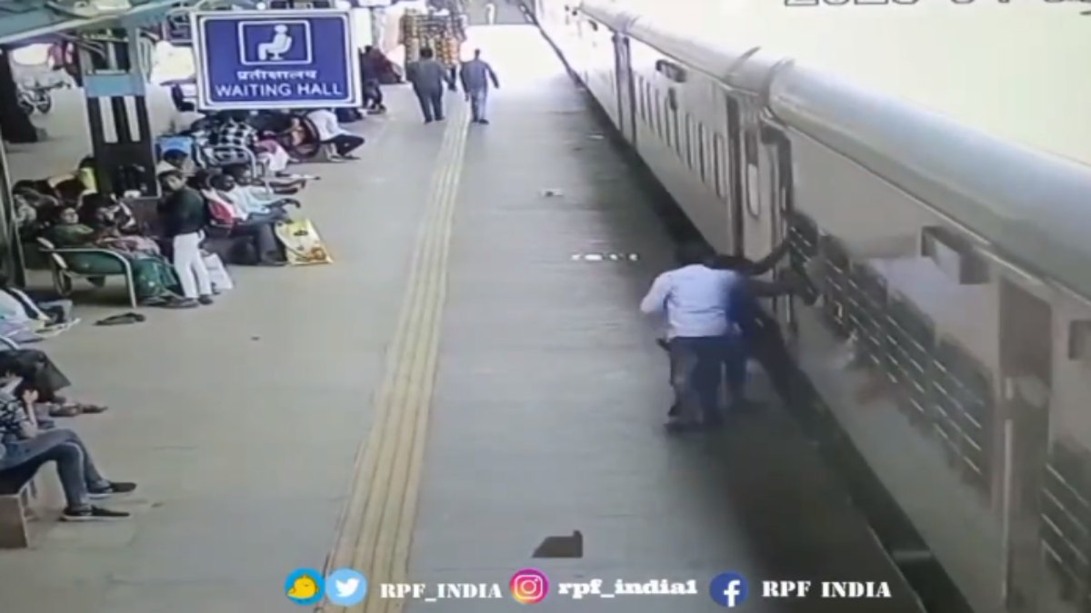 ट्रेन से गिरा पटरी में फंसा VIDEO: चढ़ते समय दो यात्रियों के टकराने से जान पर बन आई, आरपीएफ जवानों ने बचाई जान