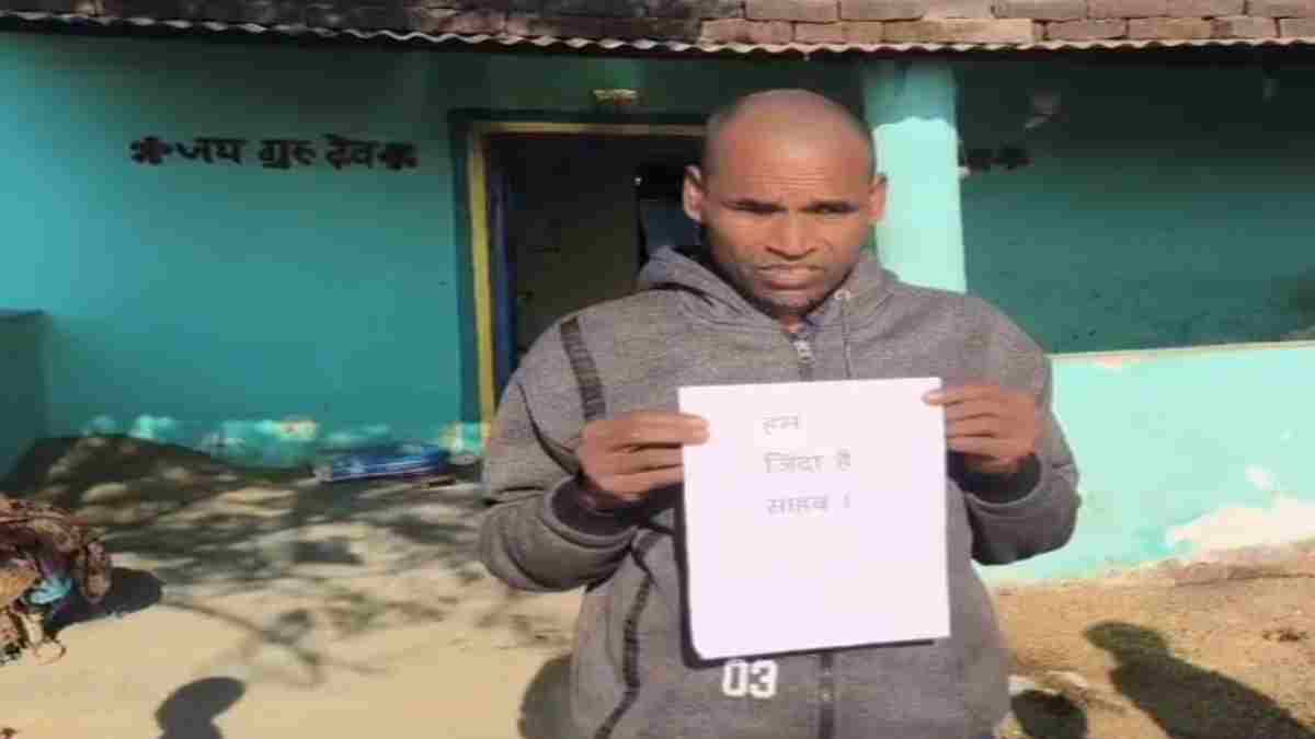 साहब मैं जिंदा हूं…तख्ती लगाकर दफ्तर के चक्कर काट रहा पति, इधर पत्नी ले रही विधवा पेंशन के साथ गुजारा भत्ता, जानें क्या है पूरा मामला 